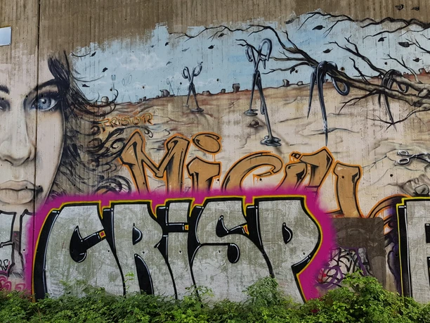 Graffiti Großflächiges Graffiti mit Frauenporträt, Schriftzügen und Scherenmotiven an Betonwand
