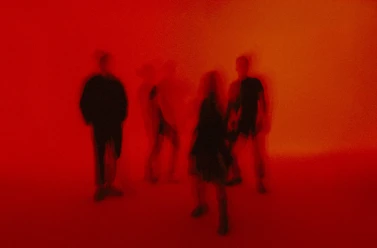 Blurred silhouettes of bands in red light at Shoegaze Fuzz Night