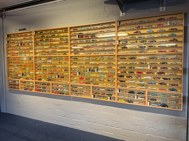 Große Holzvitrinen voller Modellautos an einer hellen Backsteinwand im PS-Speicher Einbeck.