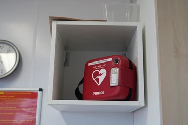 Defibrillator DLRG Hauptstrand Ein Defibrillator in einem Regal an der Wand