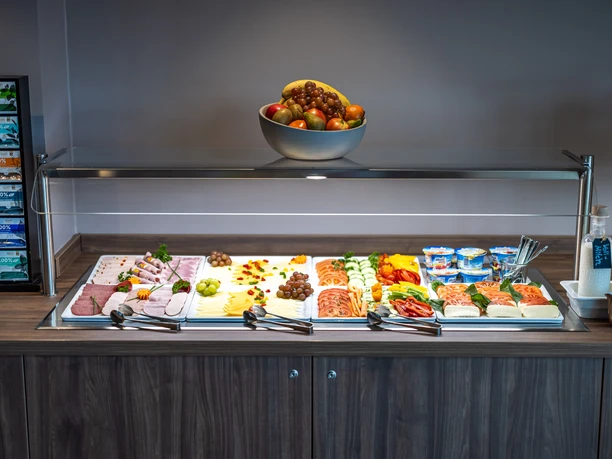 Reichhaltiges Frühstücksbuffet mit Obst, Aufschnitt, Käse und frischem Gemüse