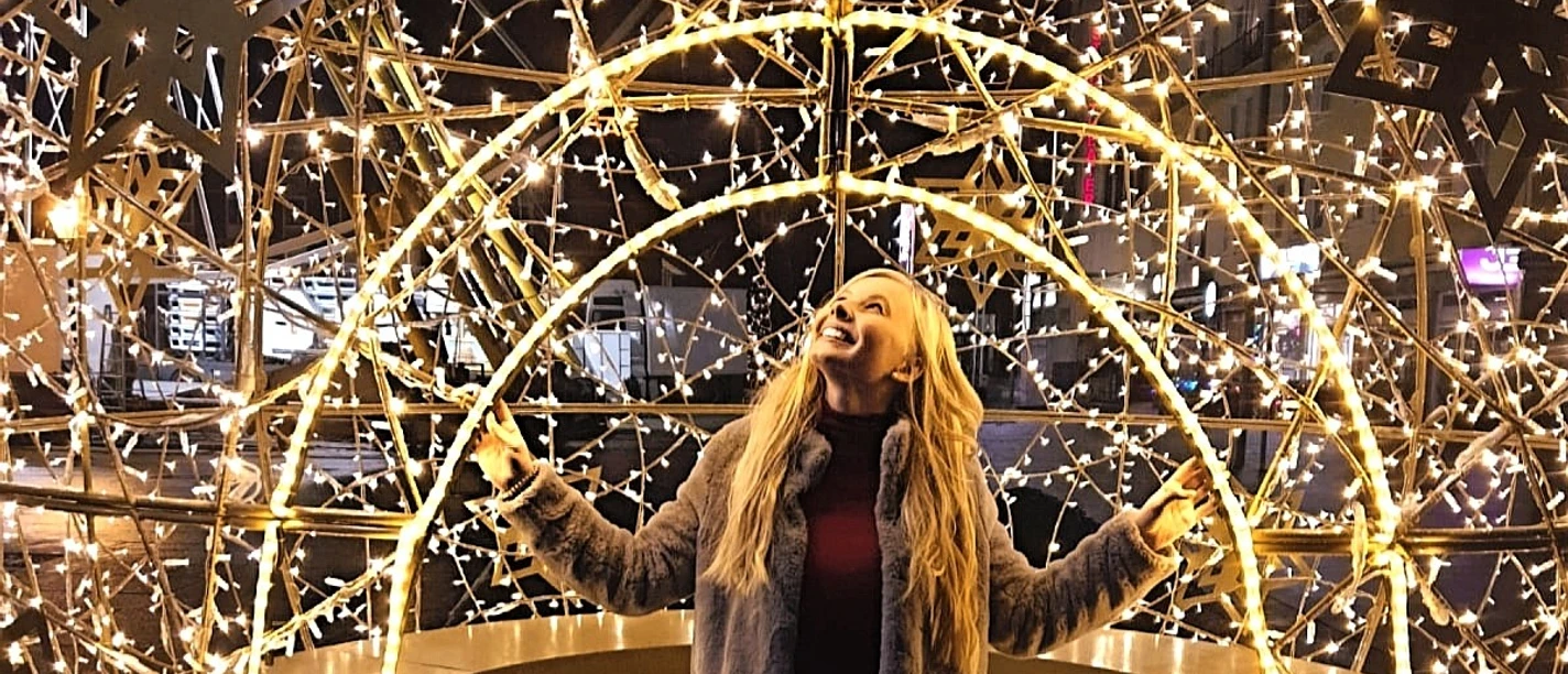 Frau in begehbarer Weihnachtskugel aus Lichtern auf dem Bremerhavener Weihnachtsmarkt.