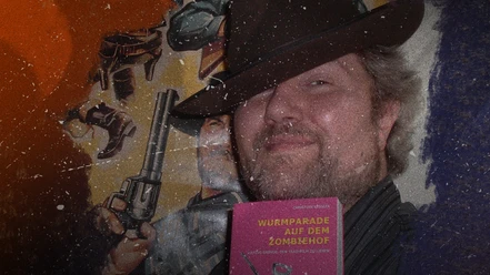 BildmaskeWeb.jpg Christian Keßler mit einem Buch