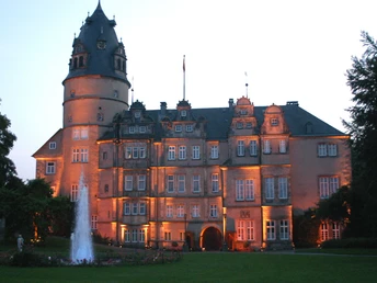 Residenzschloss Dämmerung Residenzschloss im Abendlicht mit erleuchteten Fassaden, umgeben von Bäumen und Rasenflächen.