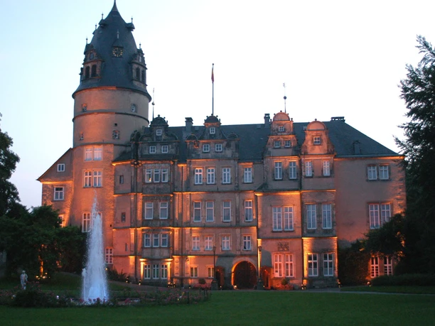 Residenzschloss Dämmerung Residenzschloss im Abendlicht mit erleuchteten Fassaden, umgeben von Bäumen und Rasenflächen.