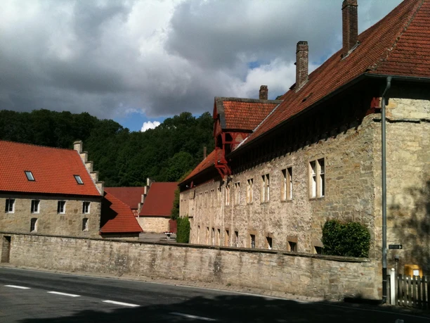 Gut Böddeken Historische Klosteranlage Gut Böddeken mit roten Ziegeldächern, umgeben von dichter Waldlandschaft.