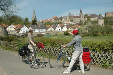 Südansicht Warburg Zwei Radfahrer betrachten die historische Altstadt von Warburg mit ihren markanten Kirchtürmen.