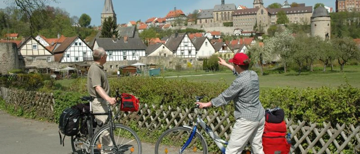 Südansicht Warburg Zwei Radfahrer betrachten die historische Altstadt von Warburg mit ihren markanten Kirchtürmen.
