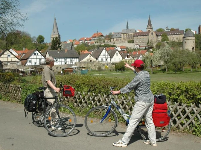 Südansicht Warburg Zwei Radfahrer betrachten die historische Altstadt von Warburg mit ihren markanten Kirchtürmen.