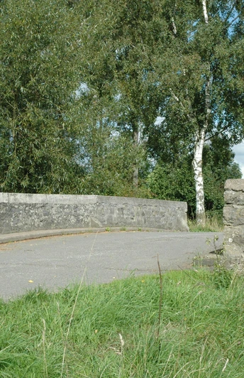 Heubachbrücke bei Eichholz Steinerne Brücke überquert einen kleinen Bach, umgeben von grüner Vegetation und sanftem Tageslicht.