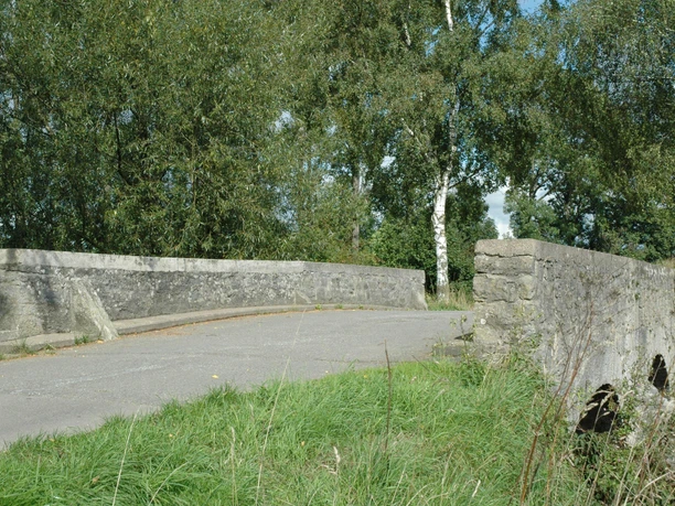 Heubachbrücke bei Eichholz Steinerne Brücke überquert einen kleinen Bach, umgeben von grüner Vegetation und sanftem Tageslicht.