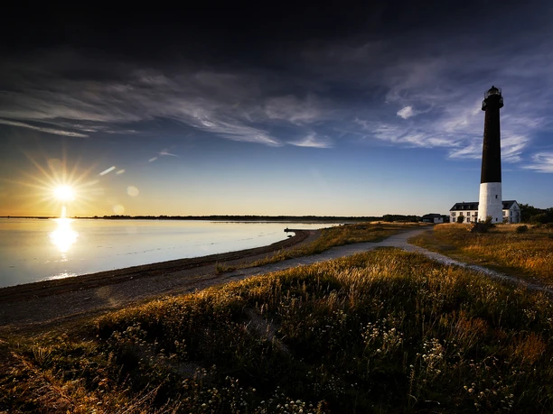 Weitläufige Landschaft am Meer, Sonnenuntergang und Leuchtturm