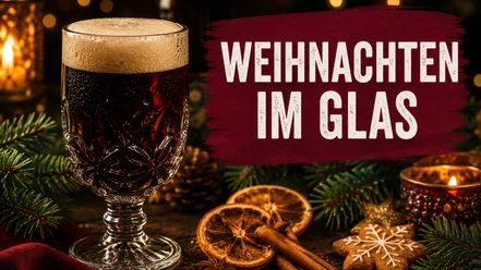 Dunkles Bier im Kristallglas mit Zimtstangen, Orangen und Schriftzug Weihnachten im Glas.