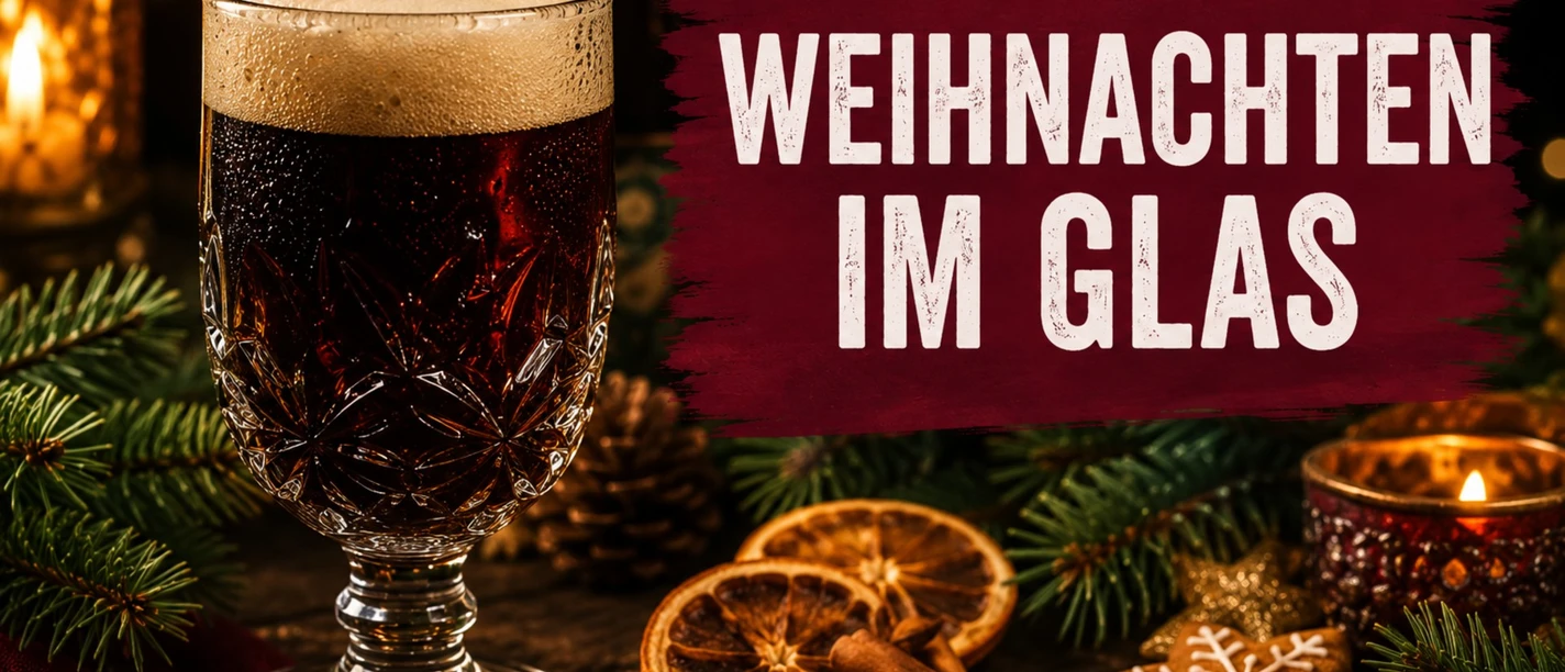 Dunkles Bier im Kristallglas mit Zimtstangen, Orangen und Schriftzug Weihnachten im Glas.
