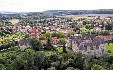 Schloss Varenholz mit seinen markanten Türmen erhebt sich vor einer malerischen Dorfkulisse bei Kirchberg.