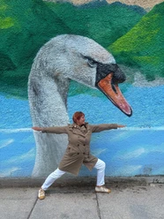 Yogahaltung vor Graffiti mit einem Schwanenkopf