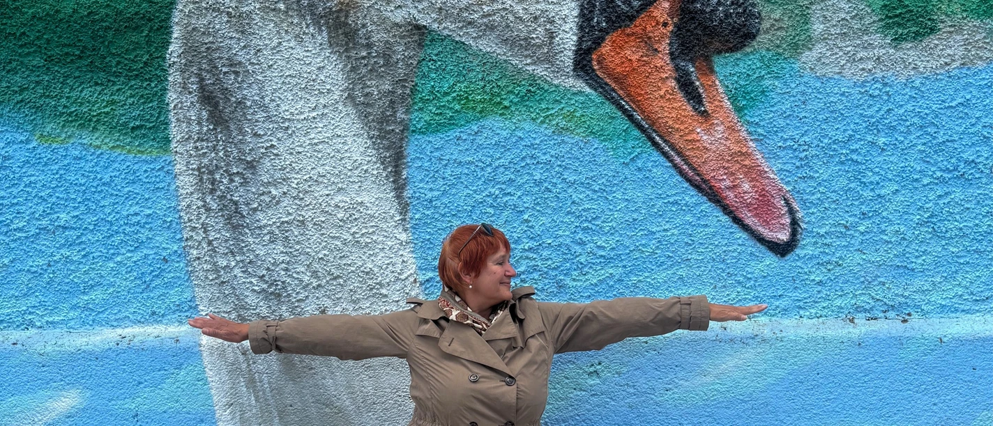 Yogahaltung vor Graffiti mit einem Schwanenkopf