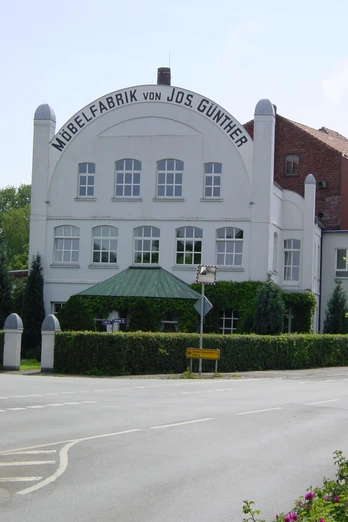Möbelmuseum Historisches dreistöckiges Gebäude der Möbelfabrik Jos. Gunther mit Runddach und traditioneller Fassade.