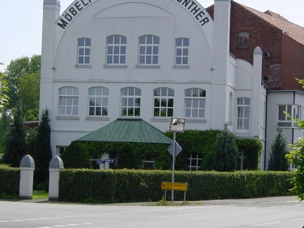 Möbelmuseum Historisches dreistöckiges Gebäude der Möbelfabrik Jos. Gunther mit Runddach und traditioneller Fassade.