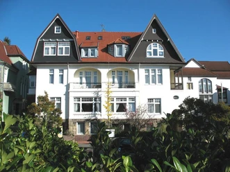 Die Kurvilla Pauline präsentiert eine prächtige Fassade im spätviktorianischen Stil mit Erkern und hohen Giebeln.