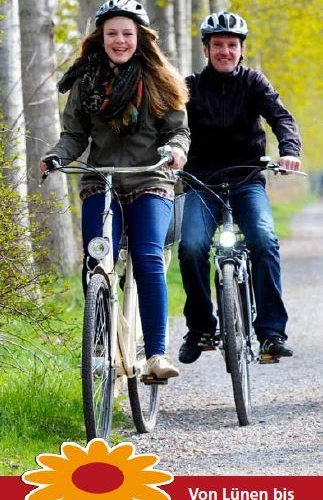 Flyer der LGS-Route Zwei fröhliche Radfahrer auf einem Waldweg mit Plakat der Landesgartenschau-Route.
