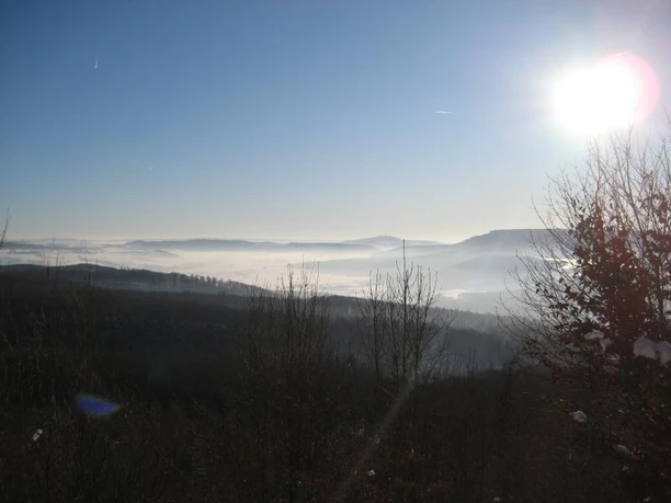 Blick vom Wanderweg am Winterberg Blick über neblige Täler und bewaldete Hügel bei Sonnenaufgang vom Winterberg-Wanderweg.
