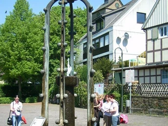 Der Widukindbrunnen in Enger zeigt eine historische Reiterfigur auf einem von Bögen umgebenen Brunnen.
