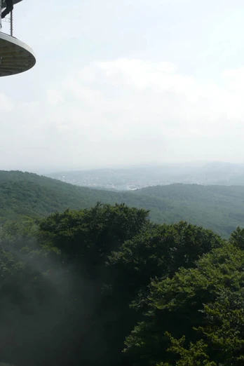 Vom Fernsehturm auf der Hünenburg bei Bielefeld Blick vom Aussichtsturm über bewaldete Hügel und entfernte Täler bei leicht bewölktem Himmel.