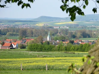 Aussicht vom Keilberg: Weites, grünes Tal mit Dorf im Vordergrund und Hügeln im Hintergrund.