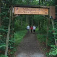Aktiv-Park im Eggegebirge Eingang zum Aktiv-Park im Eggegebirge, mit drei Personen auf einem Waldweg beim Nordic Walking.