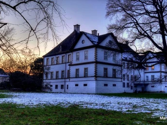 Weserhöhen Schloss Wehrden Das Schloss Wehrden erhebt sich majestätisch umgeben von Bäumen, mit leichtem Schnee auf dem Boden.