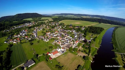Weserhöhen Wehrden wandern wo es Spass macht Luftaufnahme von Wehrden: Blick auf das Dorf, umliegende Felder und den angrenzenden Fluss.