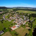 Weserhöhen Wehrden wandern wo es Spass macht Luftaufnahme von Wehrden: Blick auf das Dorf, umliegende Felder und den angrenzenden Fluss.
