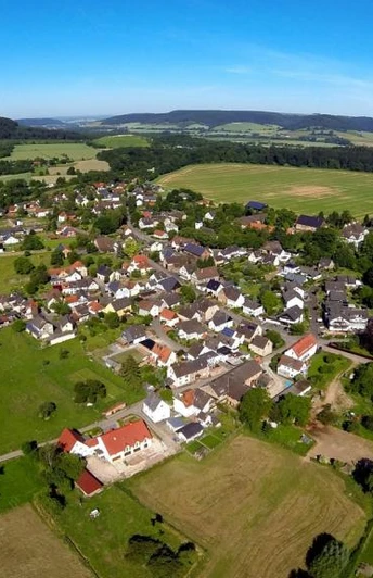 Weserhöhen Wehrden wandern wo es Spass macht Luftaufnahme von Wehrden: Blick auf das Dorf, umliegende Felder und den angrenzenden Fluss.