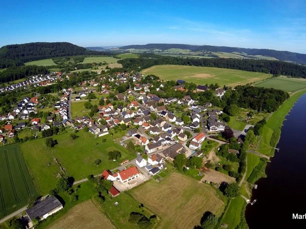 Weserhöhen Wehrden wandern wo es Spass macht Luftaufnahme von Wehrden: Blick auf das Dorf, umliegende Felder und den angrenzenden Fluss.