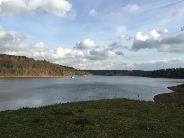 Aabachtalsperre Bad Wünnenberg Aabachtalsperre bei Bad Wünnenberg mit ruhigem Wasser, umgeben von bewaldeten Hügeln unter Wolkenhimmel.