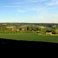 Blick vom Bierenberg auf Blankenau Weitläufige Landschaft mit grünen Feldern und Wäldern, am Horizont verstreute Dörfer und sanfte Hügel.
