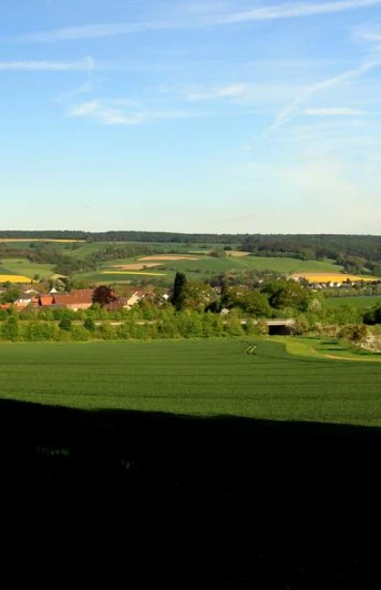 Blick vom Bierenberg auf Blankenau Weitläufige Landschaft mit grünen Feldern und Wäldern, am Horizont verstreute Dörfer und sanfte Hügel.