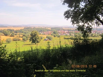 Blick über Vinsebeck hinweg ins weite Emmertal mit sanften Hügeln und weiten Feldern im Hintergrund.