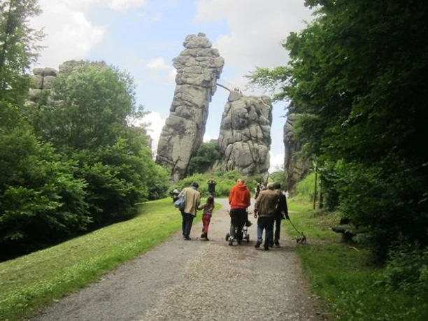 Externsteine, Natur- und Kulturdenkmal - das bedeutende Ausflugsziel im Naturpark Teutoburger Wald Gruppe von Menschen auf einem Weg, gesäumt von imposanten Felsformationen im Teutoburger Wald.