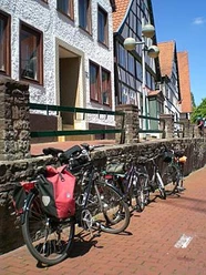 Altstadt Vlotho Fahrräder lehnen an einer Steinmauer in Vlotho vor Fachwerkhäusern mit roten Ziegeldächern.