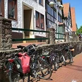 Altstadt Vlotho Fahrräder lehnen an einer Steinmauer in Vlotho vor Fachwerkhäusern mit roten Ziegeldächern.