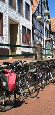 Altstadt Vlotho Fahrräder lehnen an einer Steinmauer in Vlotho vor Fachwerkhäusern mit roten Ziegeldächern.
