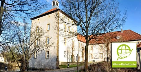 Gut Bustedt Historisches Gut Bustedt mit gelber Fassade und Turm im Vordergrund, Bäume im Winterkleid.