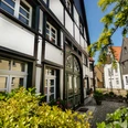 Innenstadt Lünen Fachwerkhäuser in der Altstadt von Lünen bei sonnigem Wetter, umgeben von grüner Vegetation.