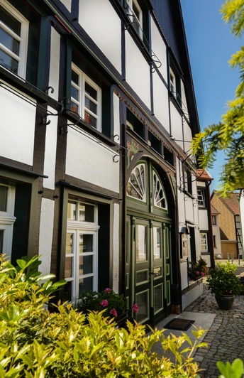 Innenstadt Lünen Fachwerkhäuser in der Altstadt von Lünen bei sonnigem Wetter, umgeben von grüner Vegetation.