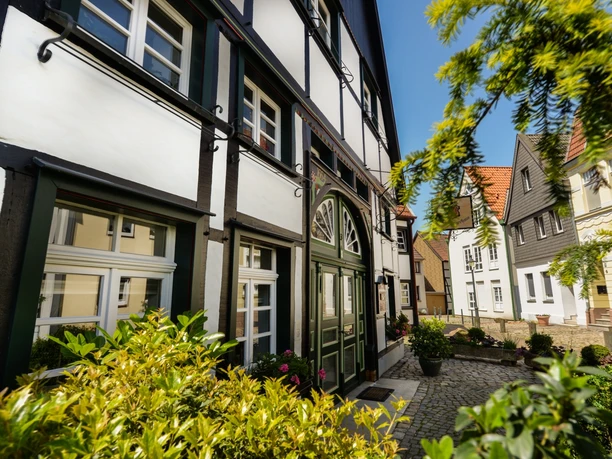 Innenstadt Lünen Fachwerkhäuser in der Altstadt von Lünen bei sonnigem Wetter, umgeben von grüner Vegetation.
