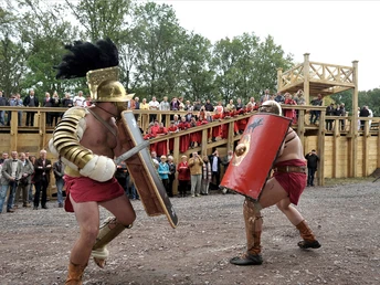 Römerpark Bergkamen Gladiatorenkampf im Römerpark Bergkamen vor großem Publikum auf einer historischen Holztribüne.