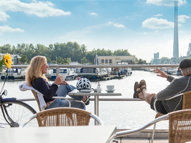Auszeit im Hafen Marina Rünthe Bergkamen Zwei Personen entspannen sich auf einer Terrasse am Wasser des Marina Rünthe Hafens in Bergkamen.
