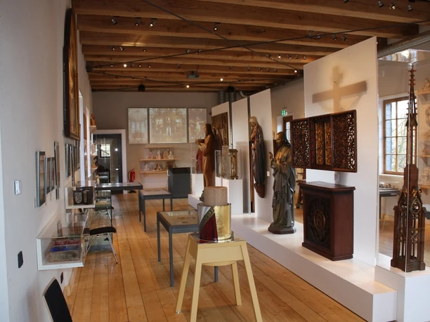 Museum Wiedenbrücker Schule Innenansicht des Museums Wiedenbrücker Schule mit Holzdecke, Skulpturen und kunstvollen Schränken.